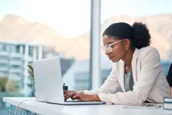 Young professional working on laptop in office.