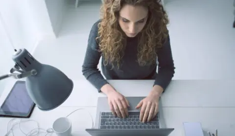 woman typing on laptop