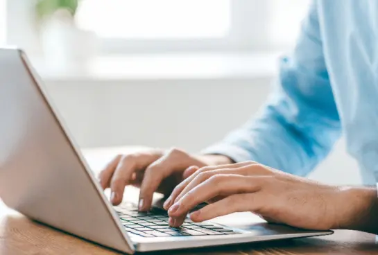 hands typing on laptop