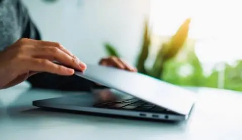 hands opening laptop