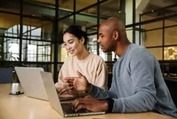 Two accounting colleagues working on laptops