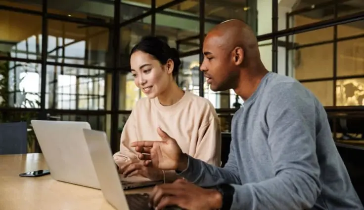 Two accounting colleagues working on laptops