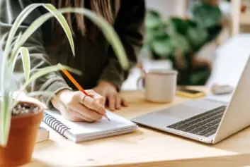 woman working on laptop with plant