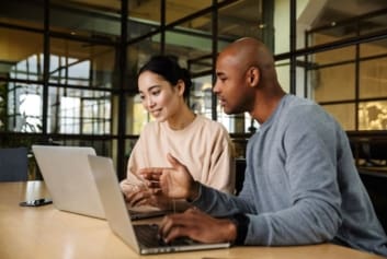 Two accounting colleagues working on laptops