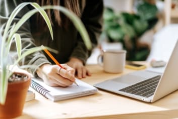 woman working on laptop with plant